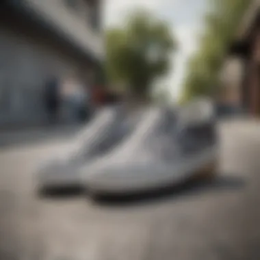 A pair of grey checkered slip-on Vans on a skateboard