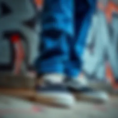Close-up of Vans shoes paired with cuffed blue pants against a graffiti backdrop