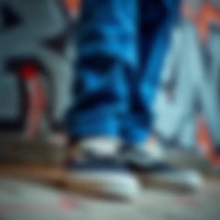 Close-up of Vans shoes paired with cuffed blue pants against a graffiti backdrop