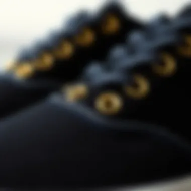 Close-up of gold eyelets on black Vans shoes