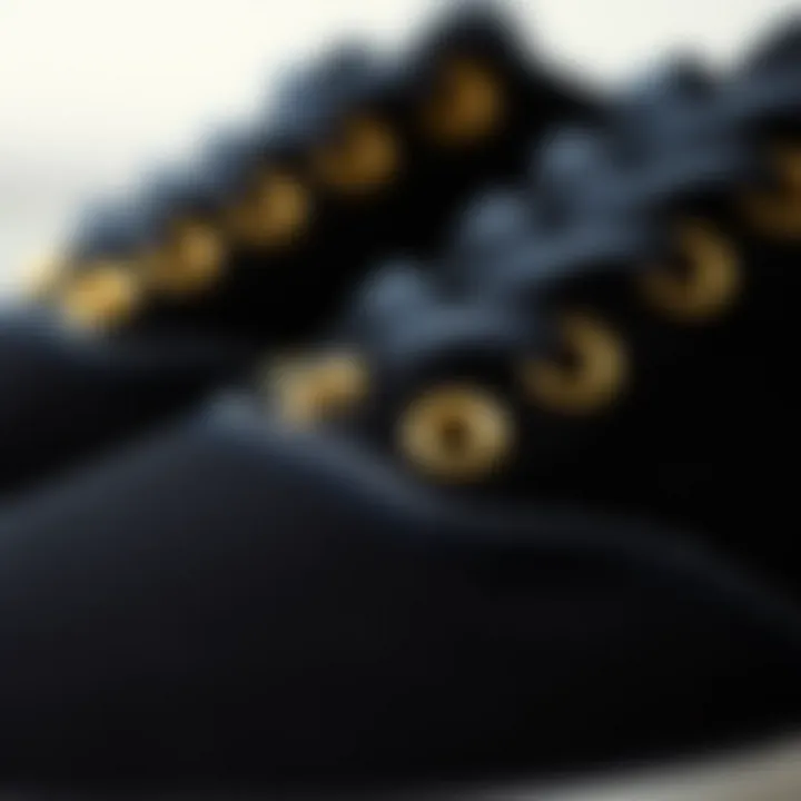 Close-up of gold eyelets on black Vans shoes