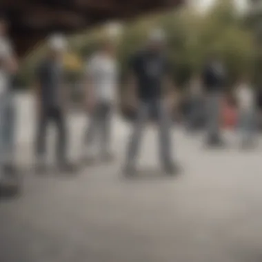 A group of skaters gathering, all wearing low rise grey jeans, in an urban skatepark.