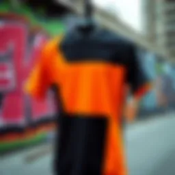 A vibrant black and orange t-shirt displayed against a graffiti backdrop