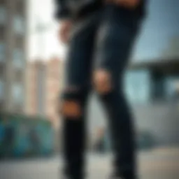 A close-up view of stylish ripped black pants worn in an urban skate environment