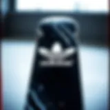 A black and white skateboard featuring the Adidas logo