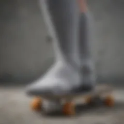 A close-up of grey Adidas crew socks resting on a skateboard, highlighting their texture and design.